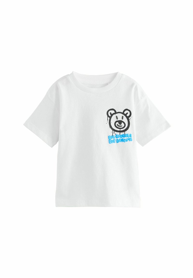 T-shirt bianco in cotone a maniche corte, con una grafica di un orso nero e il testo blu "GRANDI OBIETTIVI GRANDI SOGNI" sul lato sinistro anteriore.