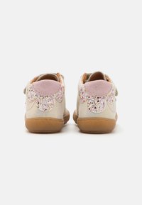 Kinderschuhe mit einem Obermaterial aus cremefarbenem Leder, rosa Wildlederakzenten und glitzerndem Blumenmotiv an den Fersen. Sohle aus Gummi.