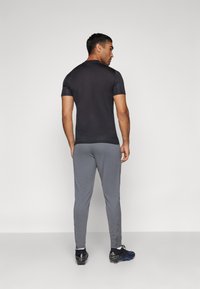 Nike Performance DRI-FIT ACADEMY PANT - Pantalones deportivos - iron grey/dragon red