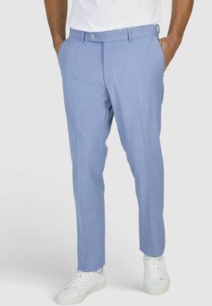 Helleblaue, maßgeschneiderte Hose aus einem glatten, strukturierten Stoff. Verfügt über seitliche Taschen, Gürtelschlaufen und einen Knopfverschluss. Kombiniert mit weißen Sneakers.