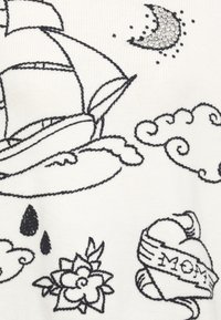 Weißer Stoff mit schwarzer Stickerei eines Schiffs, Wolken, einem Halbmond mit Strasssteinen, Regentropfen und einer Blume mit "MOM" auf einem Band.