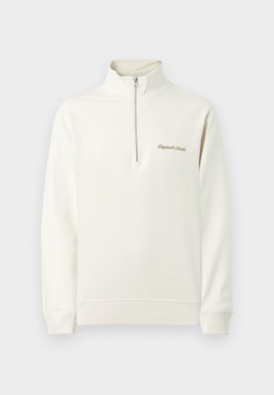 Šviesus kremas megztinis su pusiau užtrauktuku, featuring siuvinėtas tekstas ant krūtinės. Paprastas, švarus dizainas priešais vientisą foną.