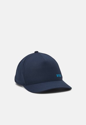 Casquette de baseball bleu marine avec une visière incurvée et un petit logo bleu "BOSS" sur le côté avant droit sur fond clair.