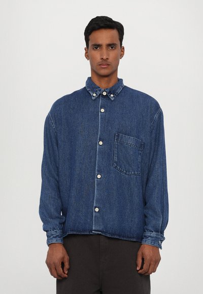 Denim button-up shirt in dark blue with a chest pocket, long sleeves, and a collared neckline featuring contrasting button details.