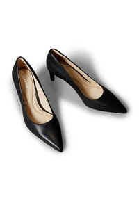 Paire d'escarpins noirs en cuir à bout pointu pour femmes avec talon aiguillot bas, doublure beige et logo Calvin Klein à l'intérieur, présentés sur fond blanc.