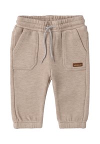 Beige Baumwoll-Sweatpants mit elastischem Bund, Kordelzug und zwei vorderen Taschen. Mit einem kleinen braunen Logosticker.