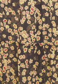Abito nero a fiori con fiori gialli e rossi. Tessuto leggero, design plissettato, presenta una leggera lucentezza e una superficie strutturata.