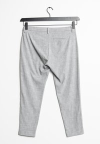 Grijze op maat gemaakte broek van gestructureerde stof, met een slim fit, een achterzak en een rechte zoom, hangend aan een zwarte hanger.