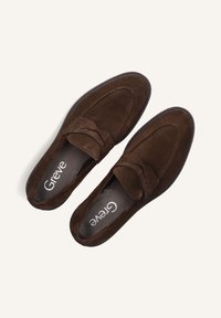 Donkerbruine suède herenslippers met pennystraps, gedetailleerde stiksels en merkzolen op een effen lichte achtergrond.