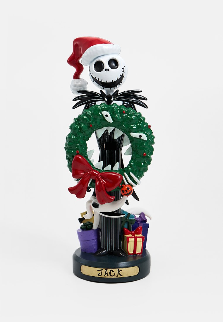 Figurita de vinilo de Jack Skellington con un gorro de Santa rojo, sosteniendo una corona verde con un lazo rojo, rodeado de regalos y decoraciones.