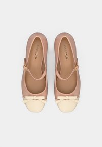 Pantofi roz din piele ecologică cu vârf crem, formă rotundă și un mic detaliu cu fundă în partea din față; bareta de gleznă cu accesorii aurii.