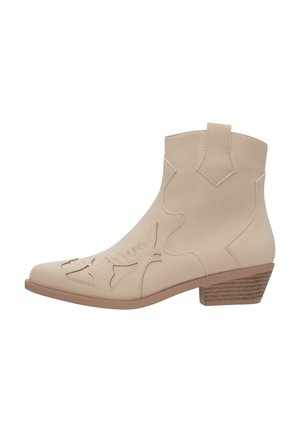 Botín de cuero beige hasta el tobillo con diseños troquelados, punta afilada y tacón de madera apilada. Presenta un sutil detalle de costura a lo largo de los bordes.