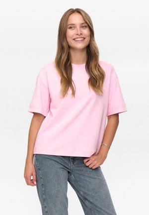T-shirt di cotone rosa con collo rotondo e maniche corte, con una vestibilità comoda e una texture liscia. Indossato con jeans azzurri.