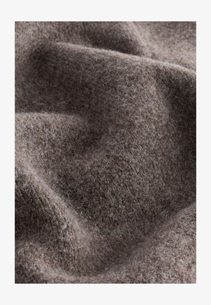 Rakeanruskea kangas, jossa on pehmeä, karvainen pinta, esittää hienovaraista, epäsäännöllistä kuviota, luoden syvyyttä ja lämpöä.