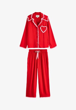 Küpsiste mustriline punane pidžaama komplekt, millel on valge pitsiline äär ja südamekujuline tasku nuppude tõttu, ning sobivad elastsed püksid. Sile tekstuur.
