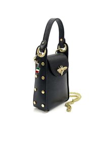Zwarte leren handtas met gouden studs, een bij-vormige sluiting, een kleine vlag sleutelhanger, een handvat aan de bovenkant en een optionele gouden schouderband.