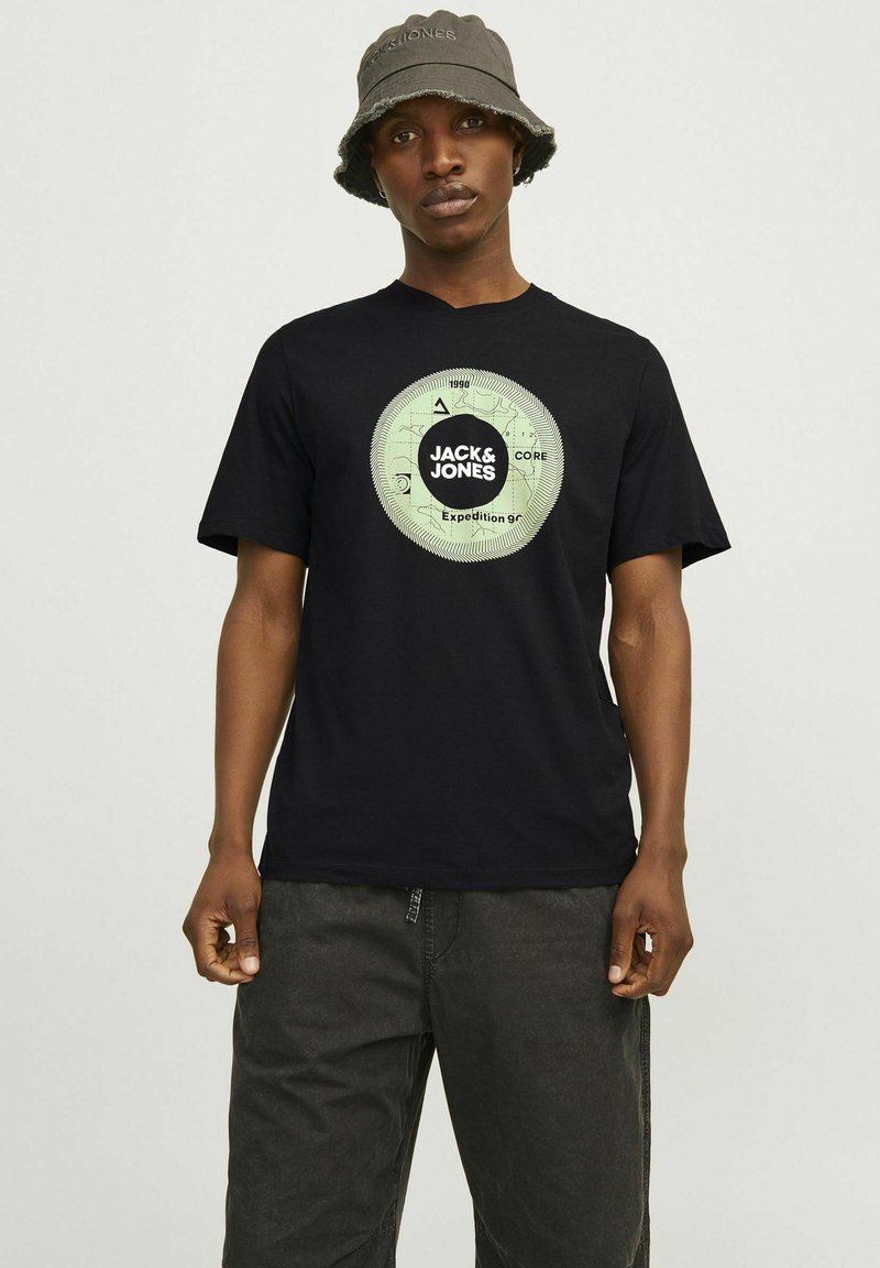 Sort bomulds T-shirt med et cirkulært grønt grafik med teksten "JACK & JONES" og "Expedition 99" på brystet, rund halsudskæring, korte ærmer.