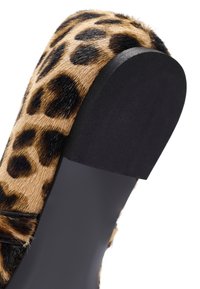Sandalia deslizante de piel de leopardo con suela de goma negra, que presenta una punta redondeada y un upper de textura suave y aterciopelada.