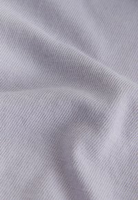 Light gray fabric with fine ribbed texture shown in close-up with gentle folds and soft lighting.