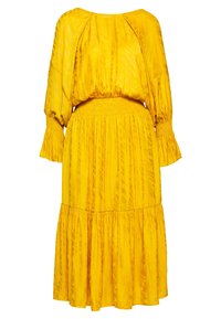 Yellow dress featuring a textured, lightweight fabric, long sleeves with ruffle cuffs, and a smocked waistline, flowing into a tiered skirt.