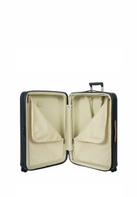Valigia rigida di colore blu navy con zip dorata, l'interno presenta una fodera beige, due compartimenti con zip e un manico retrattile.