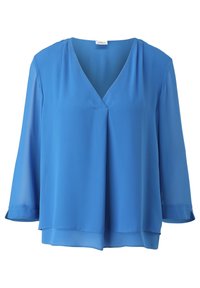 Blouse bleue pour femme à manches longues, col en V et ourlet légèrement superposé, fabriquée en tissu léger et semi-transparent.
