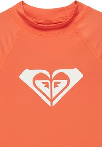 Kortärmad rash guard i stark orange, med en vit hjärtsymbol i stiliserad design. Tillverkad av smidigt, stretchy tyg.