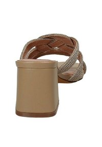 Sandalo beige con tacco alto, caratterizzato da cinturini intrecciati in materiale sintetico, un tacco largo e una suola liscia. La vista posteriore mette in evidenza l'altezza e la texture del tacco.