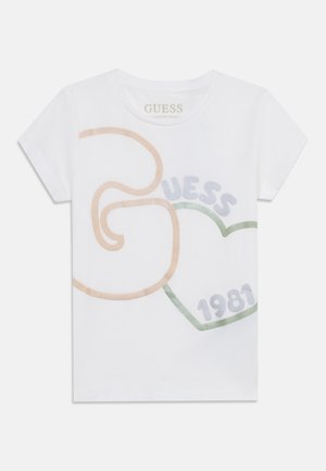 Λευκό κοντομάνικο T-shirt με αφηρημένα παστέλ σχήματα, το κείμενο «GUESS» και το «1981» τυπωμένα μέσα σε περίγραμμα καρδιάς μπροστά.