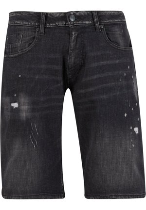 Sorte dongeribukser med en falmet finish, med lett slitasje og fem lommer. Knapplukking i livet.