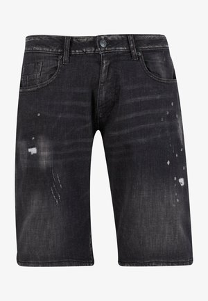 Sorte dongeribukser med en falmet finish, med lett slitasje og fem lommer. Knapplukking i livet.