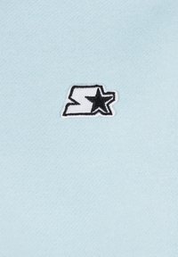 Light blue fabric with a smooth texture featuring a black and white embroidered logo of a stylized letter 'S' and a star.