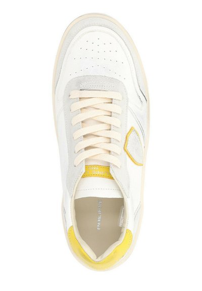 Sneaker bianca con accenti grigi e gialli, materiali in pelle e suede, punta tonda, dettagli perforati e lacci piatti beige.