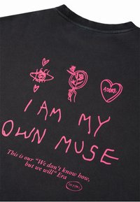 Schwarzes Stoff-T-Shirt mit pinken Grafiken und Kritzeleien, darunter "ICH BIN MEINE EIGENE MUSEN" und Blumenmuster. Weicher Stoff, Rundhals.