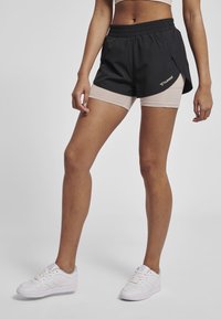 Svarta sportshorts med en lättviktsdesign, med ett inre lager i beige. Elastisk midja, sidslitsar och logodetalj på vänster sida.