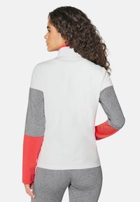 Aansluitend langlijn shirt in wit met grijze, gegoten mouwen en een koraalkleurige accent. Beschikt over een hoge kraag en een gladde, ademende stof.