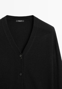 Svart cardigan med V-ringning, tillverkad av mjukt material. Har tre knappar framtill, med en slät yta och minimalistisk stil.