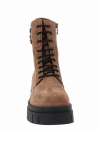 Bottine en suede marron, avec un laçage à l'avant, des lacets noirs et une fermeture éclair sur le côté. Semelle épaisse en caoutchouc noir et détails de texture subtile sur le dessus.