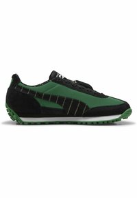 Baskets de sport noires et vertes en mesh et suède, avec un design épuré, une semelle en caoutchouc texturée verte et des rayures noires.