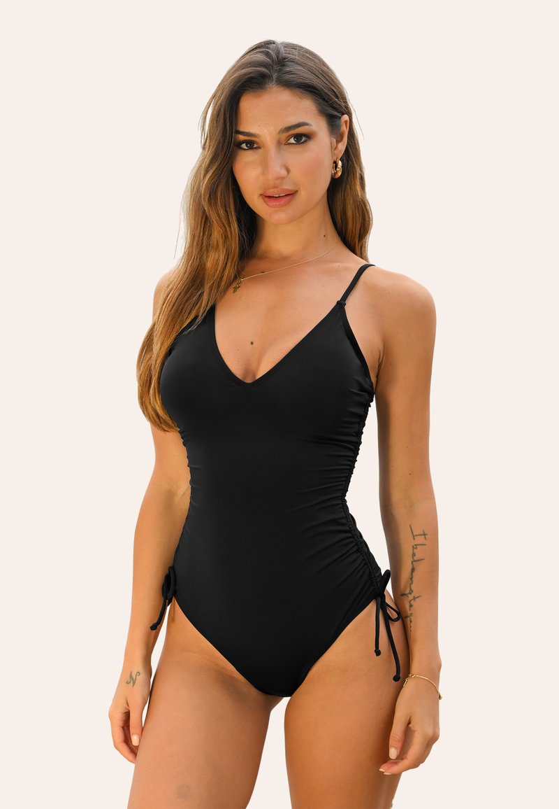 Maillot de bain noir une pièce avec bretelles réglables, décolleté en V, côtés froncés et liens sur les côtés pour un ajustement personnalisable. Texture lisse.