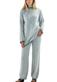 Light gray long-sleeve sweater with black trim and asymmetrical hem paired with matching elastic-waist pants, featuring a relaxed fit and soft texture.