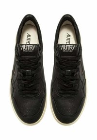 Sneakers nere con tomaia in pelle liscia, dettagli traforati, design con lacci e suola in gomma color crema. Etichetta del marchio sulla linguetta.