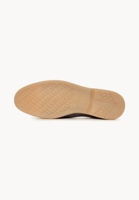 Semelle d'une chaussure marron avec une semelle extérieure en caoutchouc beige texturé montrant une adhérence à motifs et un soutien du talon.