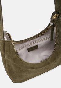 Borsa a tracolla in pelle scamosciata verde oliva con forma arrotondata, dotata di chiusura con zip dorata e una tasca interna con fodera in tessuto.