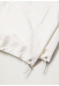 Witte stof, met een patch pocket en een trekkoord met zilverkleurige hardware aan de onderrand, gladde textuur met iets geraffineerde randen.