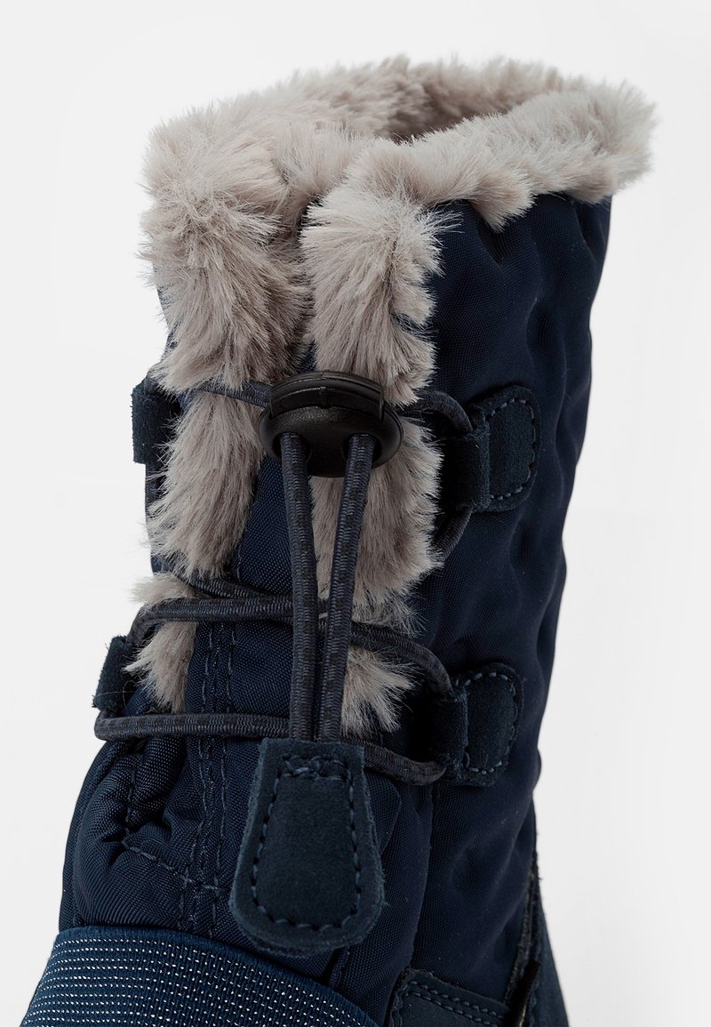 Botte d'hiver marine avec un revers en fausse fourrure, un dessus texturé, un laçage ajustable et un capuchon en caoutchouc pour une durabilité accrue.