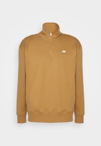 Pull marron à manches longues avec une fermeture éclair au quart et un petit logo blanc New Balance sur la poitrine gauche sur un fond uni.