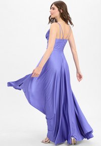 Langes lila Satin-Kleid mit tailliertem Oberteil, verstellbaren Spaghettiträgern und einem fließenden Rock, der elegant fällt.