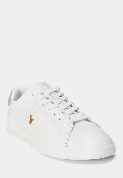 Baltas odinis sportinis batelis su baltais batraiščiais, gumine padu ir siuvinėtu rudo ir oranžinio polo žaidėjo logotipu šone.