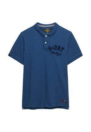 Polo de manga corta azul con cuello, dos botones, bordado "S&DRY NY State" en el pecho y un pequeño parche cerca del dobladillo.